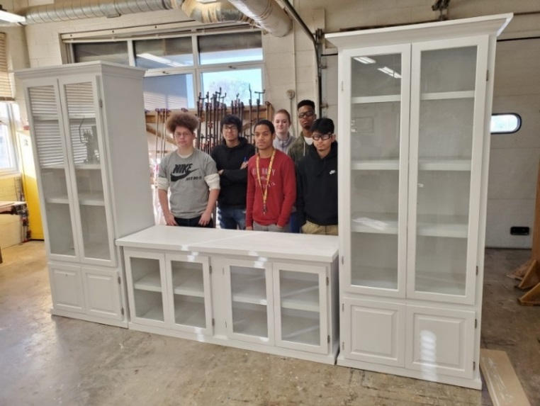 Students pose with an entertainment center created in Mr. Hatfield's construction trades class.